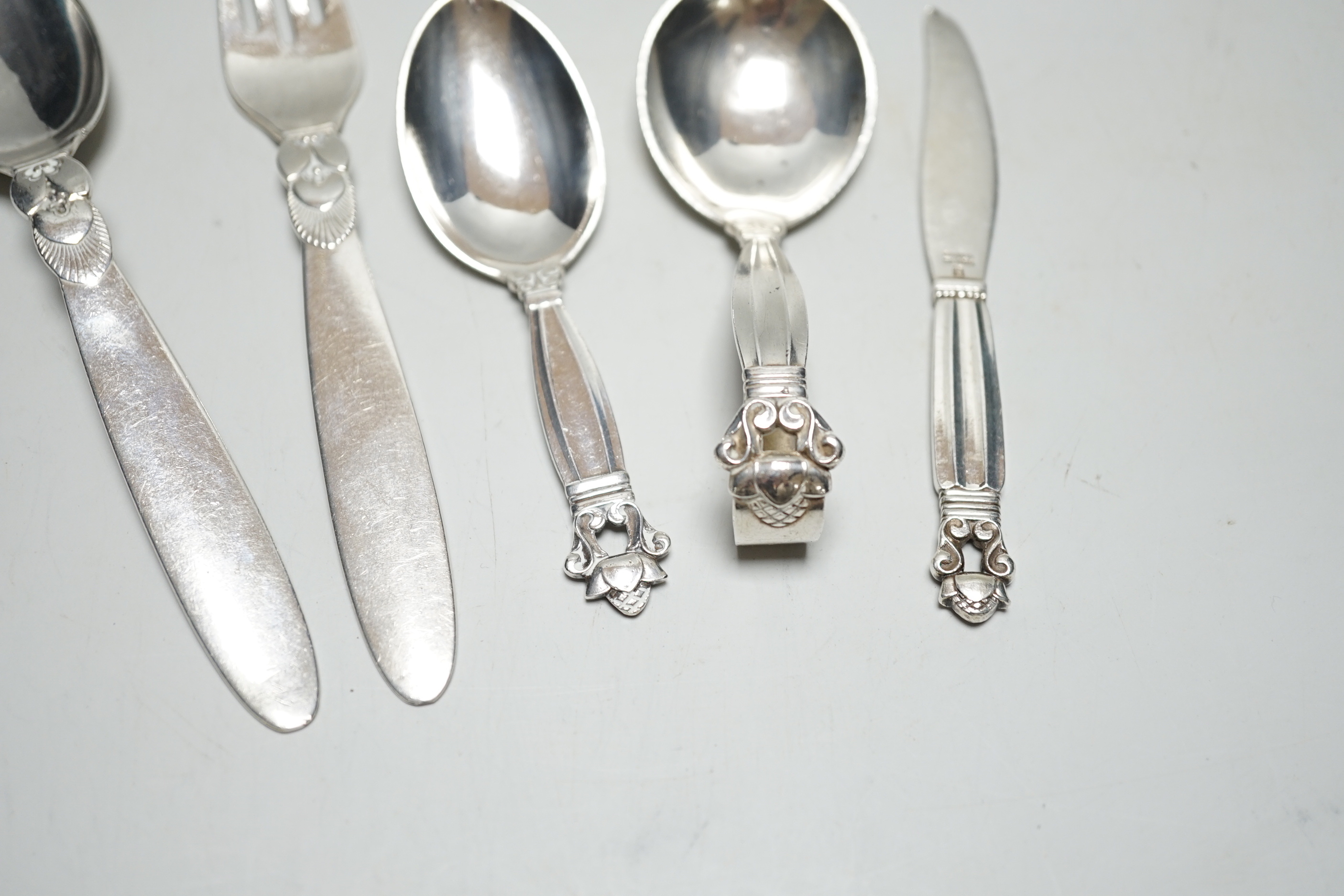 Five assorted items of Georg Jensen flatware including christening fork and spoon, caddy spoon, etc.